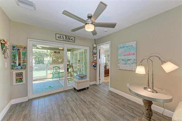 entryway with wood-type flooring, a textured ceiling, and ceiling fan