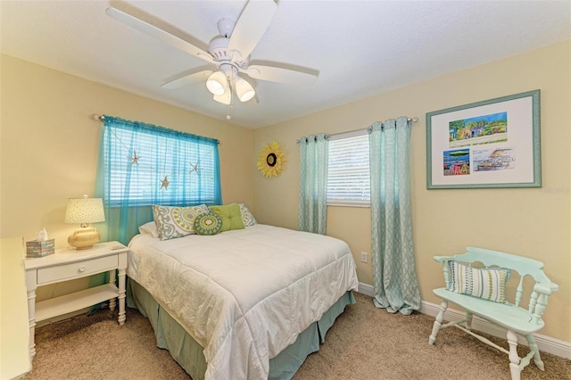 carpeted bedroom with ceiling fan and baseboards