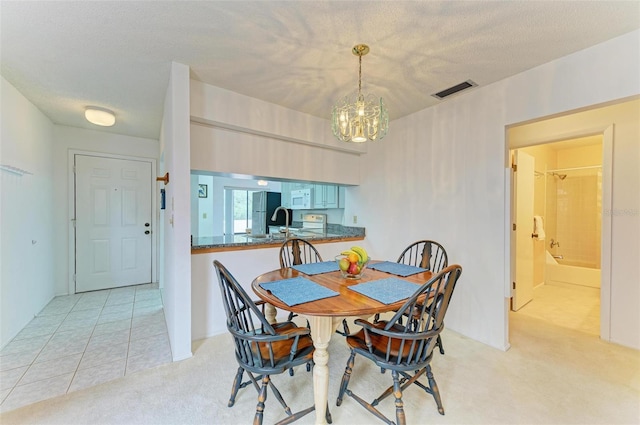 carpeted dining area featuring a textured ceiling and a notable chandelier