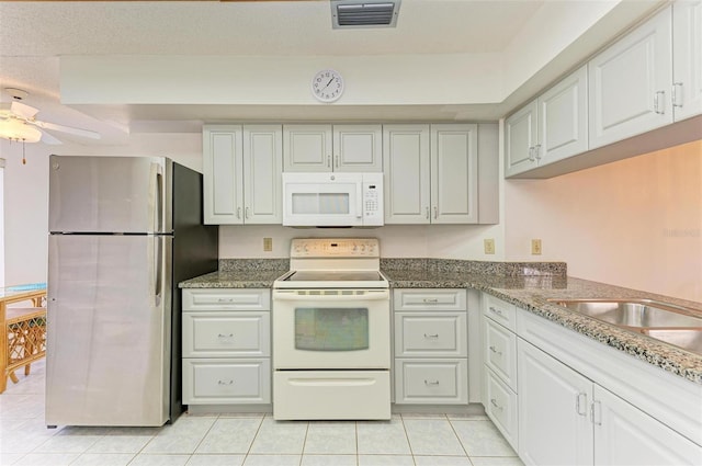 kitchen with white appliances, white cabinetry, ceiling fan, and light tile patterned flooring