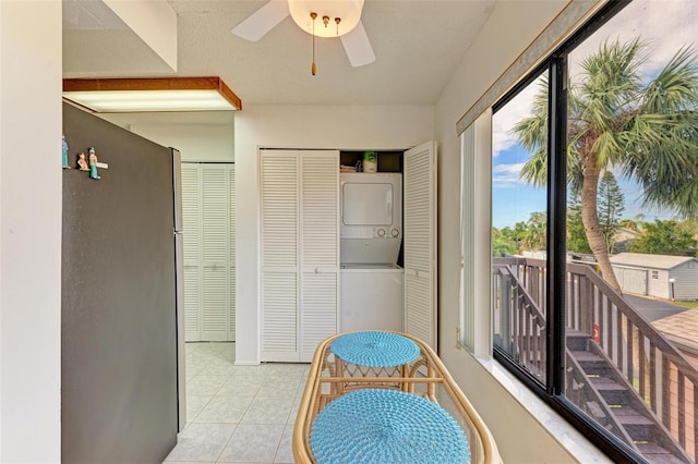 interior space featuring stacked washer and dryer and light tile patterned flooring