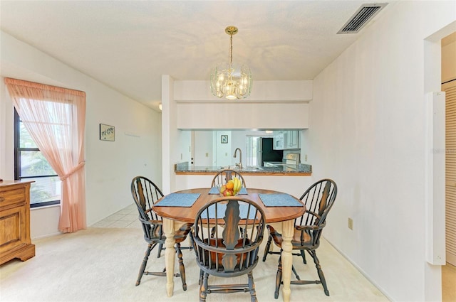 carpeted dining area with an inviting chandelier