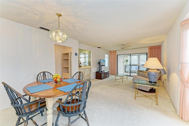 carpeted dining area featuring ceiling fan with notable chandelier and a textured ceiling