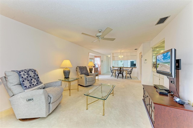 carpeted living room featuring a textured ceiling and ceiling fan