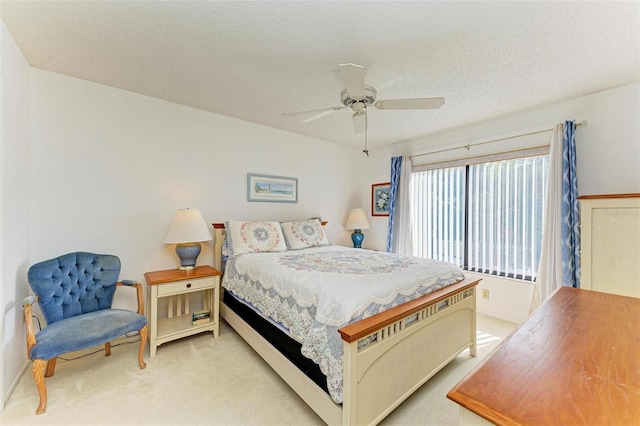 bedroom featuring ceiling fan, light carpet, and a textured ceiling