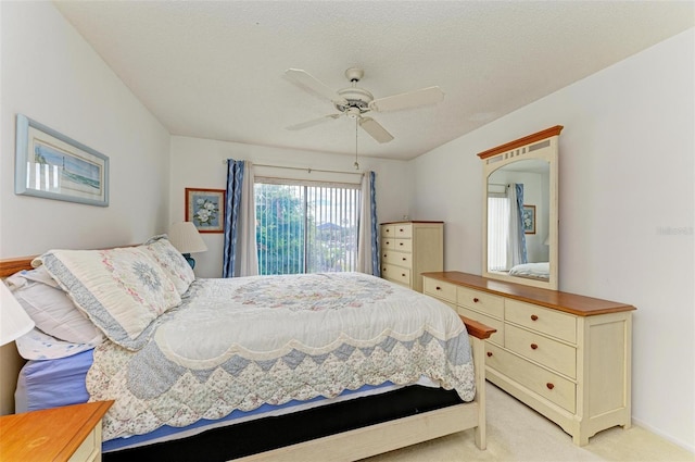 bedroom with ceiling fan, light colored carpet, and a textured ceiling