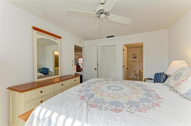 bedroom featuring ensuite bath, ceiling fan, a closet, and a textured ceiling