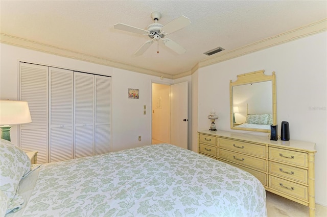 carpeted bedroom with ceiling fan, a closet, crown molding, and a textured ceiling