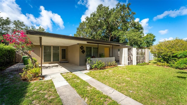 view of front facade with a front lawn and a carport