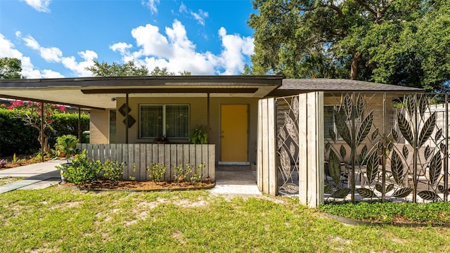 view of front facade featuring a front yard, a porch, and a carport