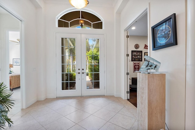 entryway with ceiling fan, light tile patterned floors, crown molding, and french doors