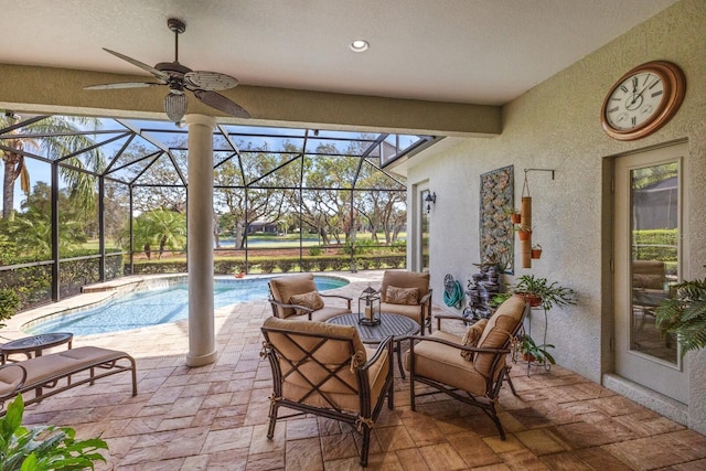 view of patio featuring an outdoor living space, glass enclosure, and ceiling fan