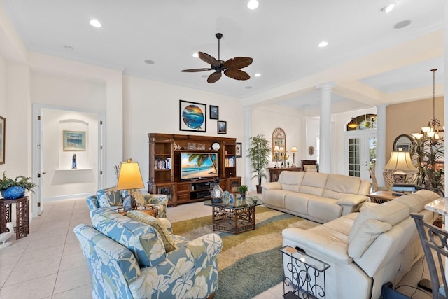 tiled living room with ornate columns, ceiling fan with notable chandelier, and ornamental molding