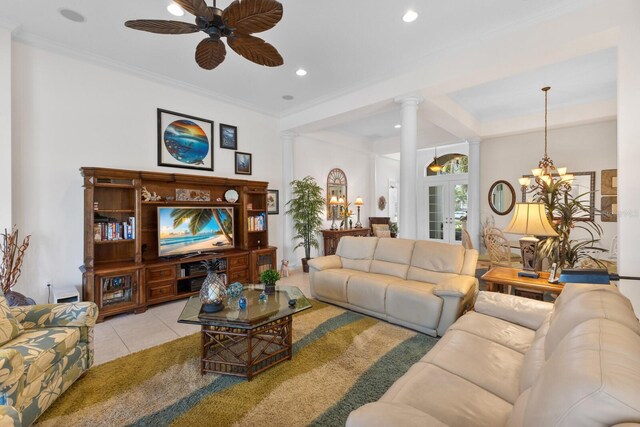 living room featuring french doors, ornate columns, ceiling fan with notable chandelier, crown molding, and light tile patterned floors