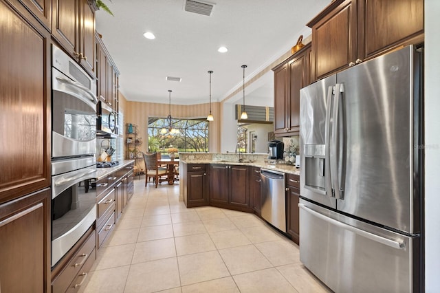 kitchen with sink, hanging light fixtures, light stone countertops, appliances with stainless steel finishes, and light tile patterned flooring