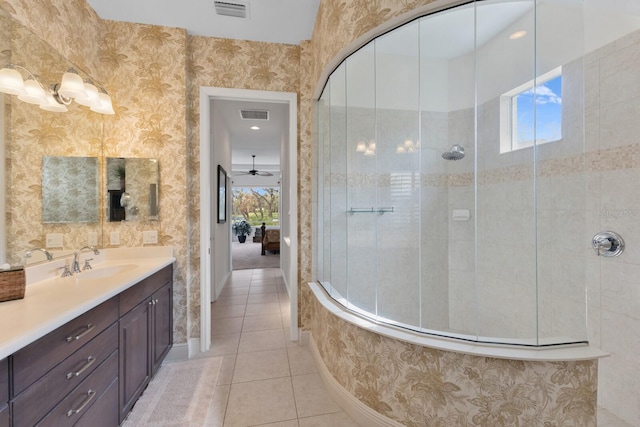 bathroom featuring tile patterned floors, ceiling fan, vanity, and tiled shower