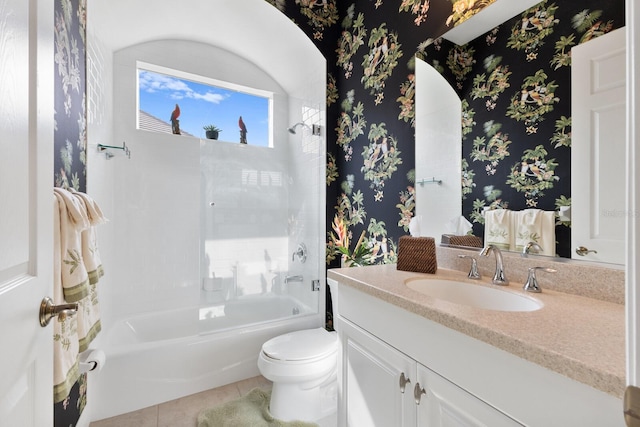 full bathroom with tile patterned floors, vanity, tiled shower / bath combo, and toilet