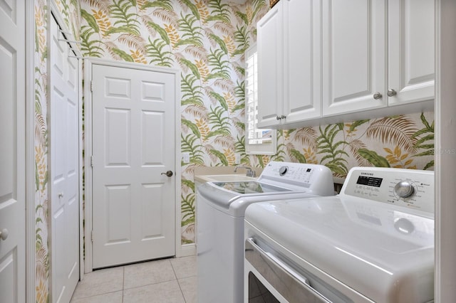 laundry area featuring cabinets, light tile patterned floors, sink, and washing machine and dryer