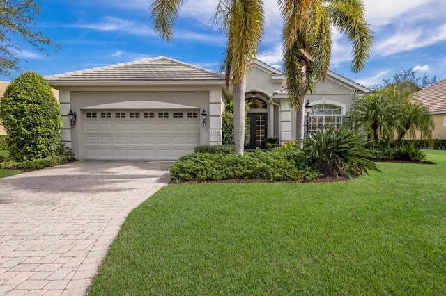 ranch-style home featuring a garage and a front lawn