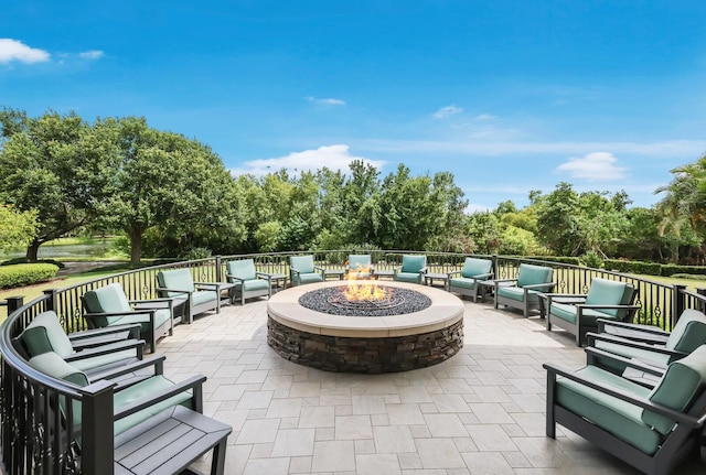 view of patio with an outdoor living space with a fire pit