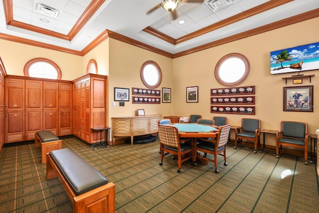 dining area with ceiling fan, a high ceiling, dark colored carpet, crown molding, and a tray ceiling