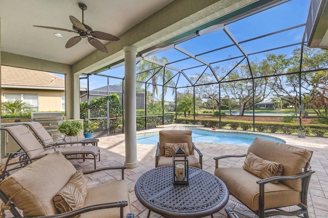 view of patio featuring an outdoor kitchen, ceiling fan, a grill, and glass enclosure