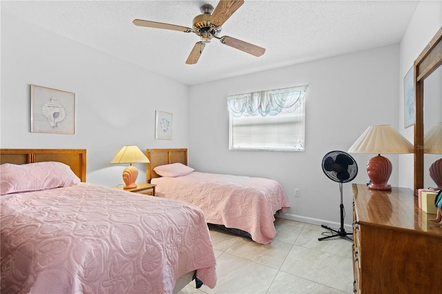 tiled bedroom featuring a textured ceiling and ceiling fan