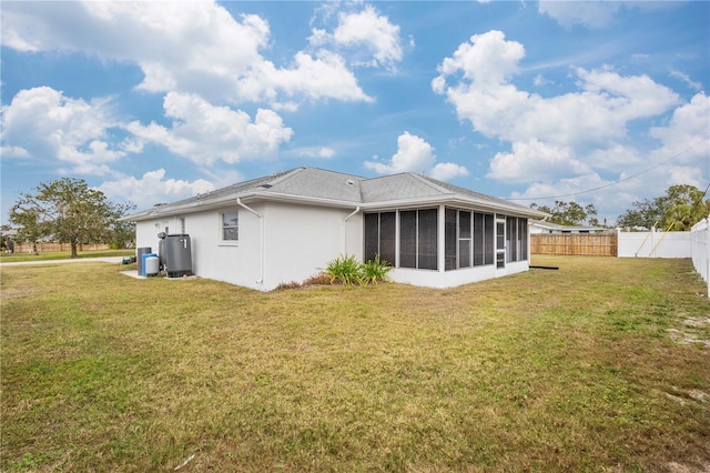 back of property with a sunroom and a lawn