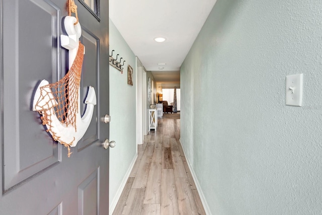 corridor with light hardwood / wood-style floors