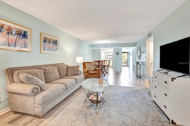 living room featuring light hardwood / wood-style floors and a textured ceiling