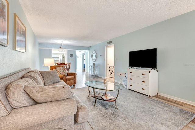 living room with light hardwood / wood-style floors and a textured ceiling