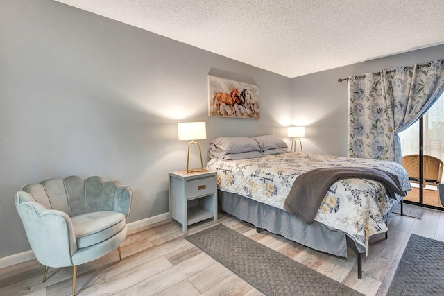 bedroom featuring light hardwood / wood-style floors and a textured ceiling