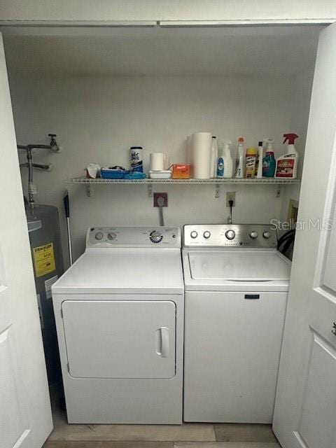 laundry area with electric water heater and washer and clothes dryer