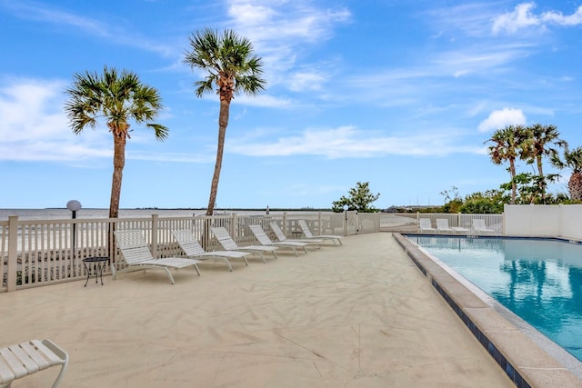 view of swimming pool featuring a patio area and a water view