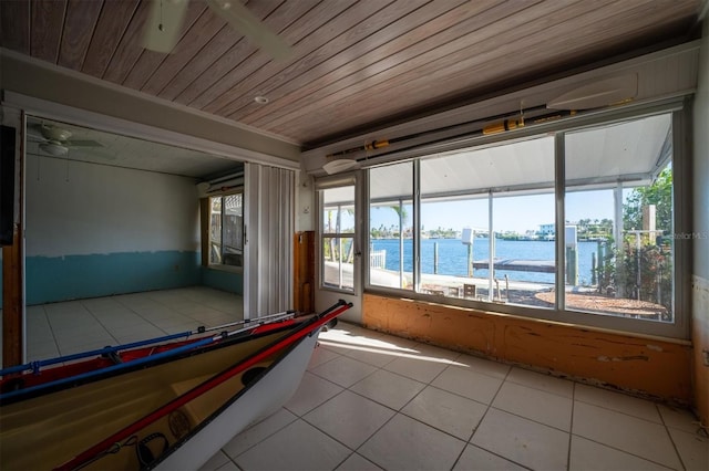 interior space featuring ceiling fan, a water view, light tile patterned floors, and wooden ceiling