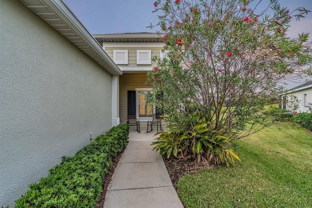 view of exterior entry featuring a yard