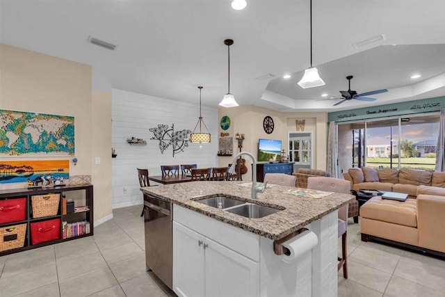 kitchen featuring light stone counters, sink, decorative light fixtures, dishwasher, and white cabinets