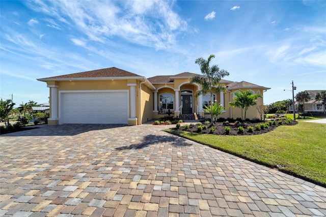 mediterranean / spanish-style house featuring a garage and a front yard