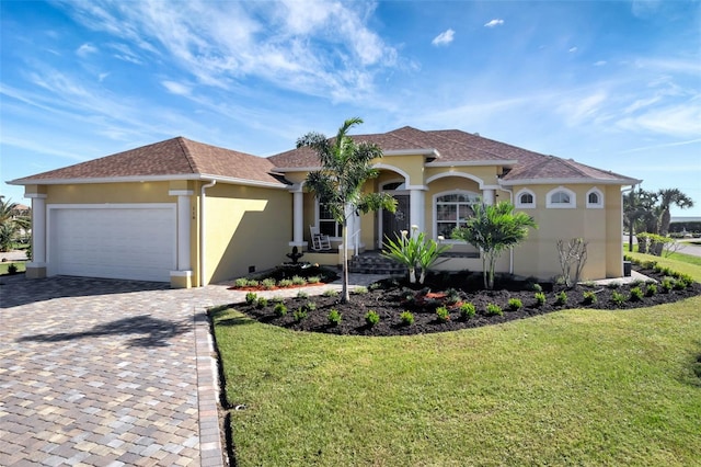 mediterranean / spanish-style home featuring a front yard and a garage