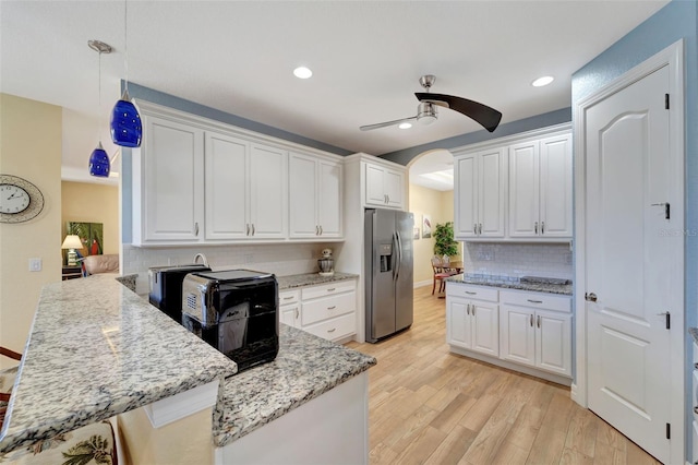 kitchen with pendant lighting, white cabinets, light hardwood / wood-style flooring, ceiling fan, and stainless steel fridge with ice dispenser