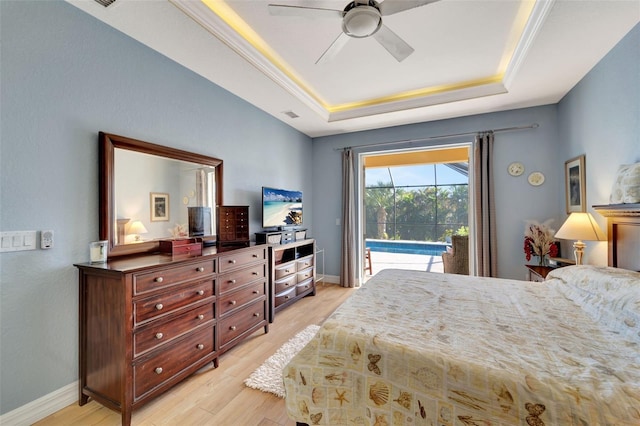 bedroom featuring access to outside, a raised ceiling, light hardwood / wood-style flooring, ceiling fan, and ornamental molding