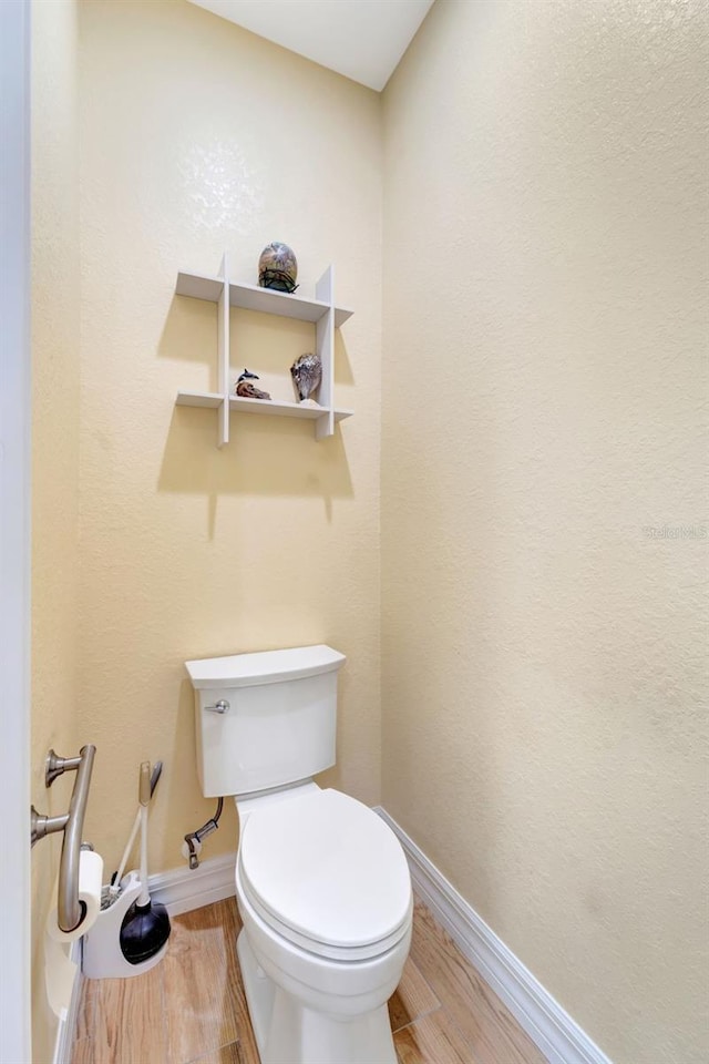 bathroom featuring hardwood / wood-style flooring and toilet