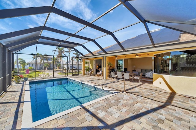 view of pool with ceiling fan, a lanai, and a patio