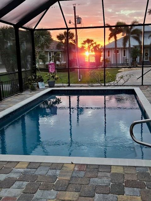 pool at dusk with a lanai