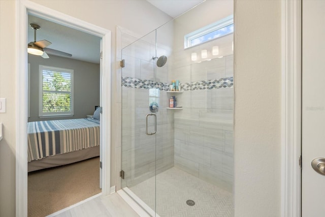 bathroom featuring a shower with door and ceiling fan