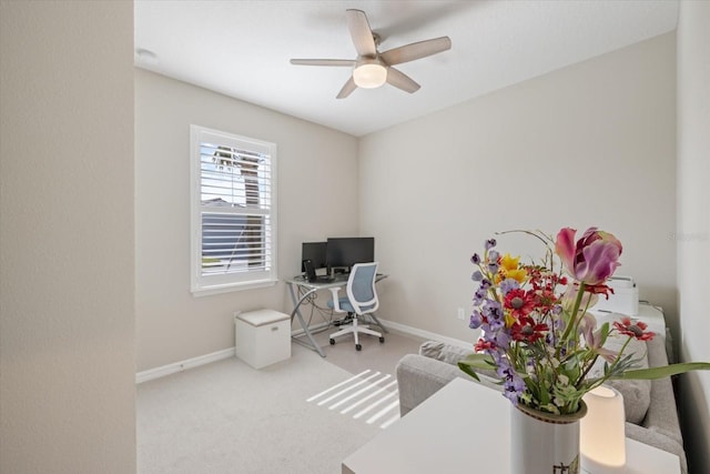 carpeted office space with ceiling fan