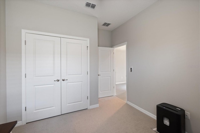 unfurnished bedroom with light carpet and a closet