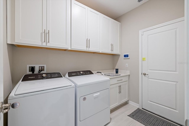 washroom featuring cabinets and washing machine and clothes dryer