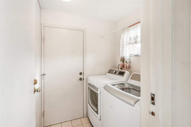 clothes washing area with light tile patterned floors and washing machine and clothes dryer