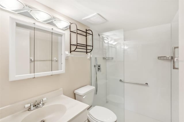 bathroom with vanity, toilet, and a shower with door